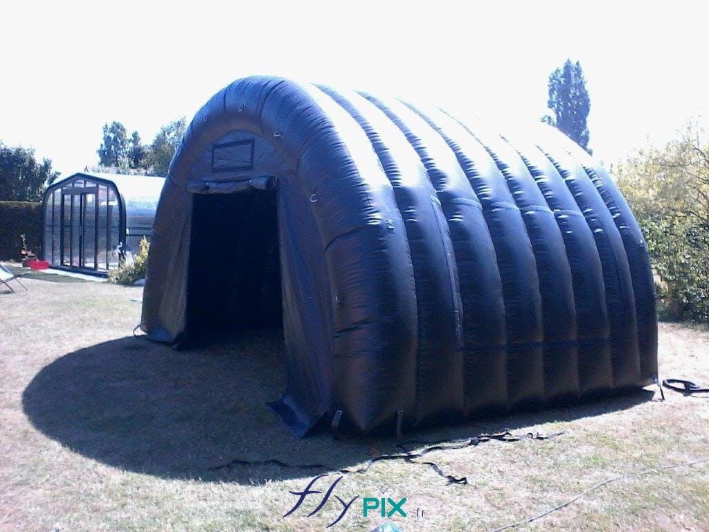 Une tente gonflable tunnel demi-lune, de couleur bleue, utilisée pour le stockage de matériel ou de machines.