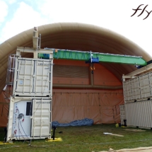 Un hangar gonflable de très grande taille, air captif, en enveloppe PVC 0,6 mm, servant de préau temporaire pour entreposer des containers. 