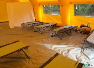 Fabrication de tente PMA (Poste Médical Avancé), de premiers secours ou de premiers soins, pour que le personnel médical, les infirmiers et les docteurs puissent travailler dans des bonnes conditions. Elle sont déployables rapidement, sur des sites d'interventions en environnement intérieur ou extérieur. Ce sont des structures gonflables air captif, étanche, et gonflées avec une pompe électrique, entièrement en enveloppe PVC 0.6 mm, et avec une bâche au sol lavable. – Droits réservés, reproduction interdite. Copyright FlyPix / Vivien LAÏLLE.
