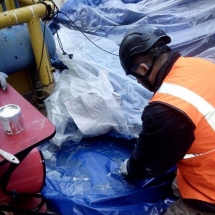 Un technicien réparateur est entrain de procéder à la restauration de l'enveloppe d'un abri gonflable.