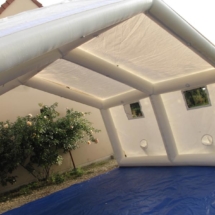 Un préau gonflable avec un toit en forme de maison, en enveloppe PVC de couleur blanche.