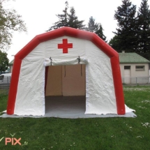 Vue de face d'une tente PMA gonflable, avec la porte d'accès à pignon et large, pour faciliter la venue des patients ou des malades.