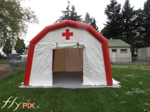 Vue de face d'une tente PMA gonflable, avec la porte d'accès à pignon et large, pour faciliter la venue des patients ou des malades.