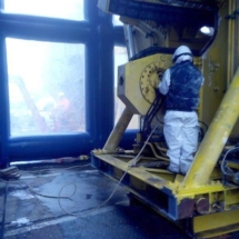 Un technicien procède au nettoyage d'une machine industrielle dans un hangar gonflable.