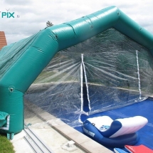 Tente gonflable abri piscine à 5 pans coupés, couvrant une partie de la piscine.
