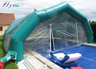 Tente gonflable abri piscine à 5 pans coupés, couvrant une partie de la piscine.