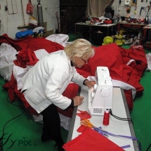 Couturière entrain de réparer une enveloppe de tente gonflable en tissus.