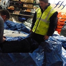 Deux techniciens procèdent à l'inspection et à la réparation d'enveloppes d'une tente gonflable.