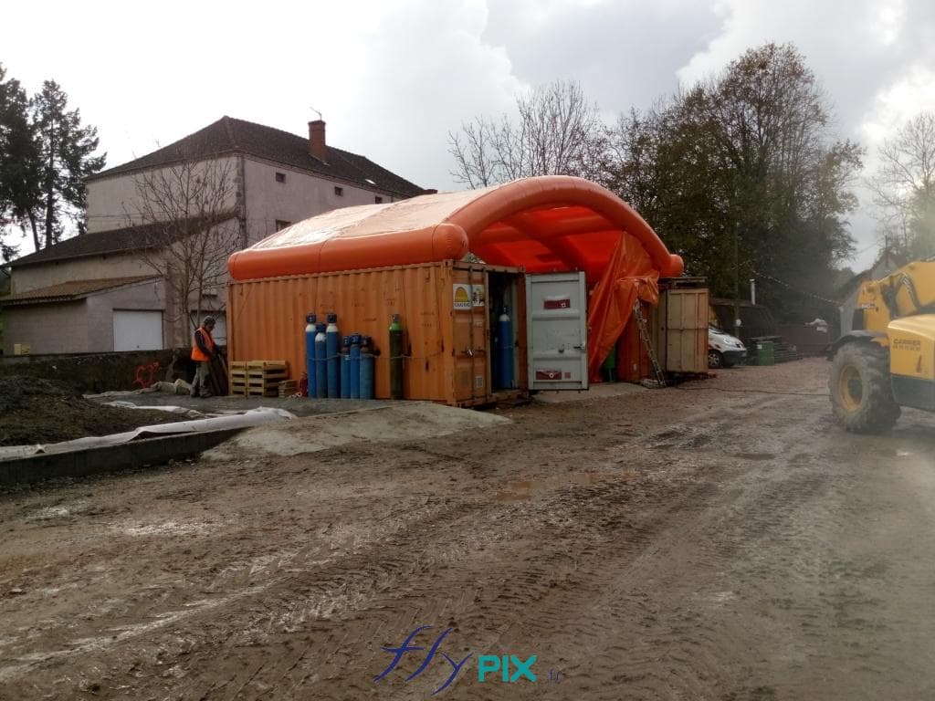 Vue générale d'un chantier Colas Rail, avec 2 containers maritimes, et un préau gonflable posé entre.