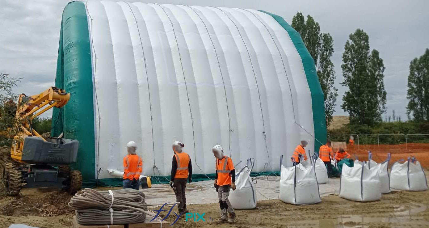 , Chantier de dépollution de site : 2 modules de hangar gonflable de S = 200 m2, soit S = 400 m2 de surface utile de travail,  Notez aussi l’épaisseur du pignon AV et des murs et de la toiture, en enveloppe PVC 0.45 mm double peau capitonnée, procurant une très grande résistance et solidité de l’ensemble de la structure gonflable. Dans cet abri gonflable, ils vont creuser et excaver le sol sur 4 à 5 m de profondeur. – Photo : copyright FlyPix/Vivien LAÏLLE, droits réservés.