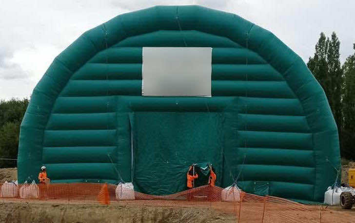 , Chantier de dépollution de site : 2 modules de hangar gonflable de S = 200 m2, soit S = 400 m2 de surface utile de travail,  Une très belle photo d’ensemble du chantier et de la tente gonflable, présentant la configuration du terrain et la disposition de l’abri gonflable une fois installé par les techniciens. C’est une très belle réalisation qui répond un un besoin spécifique très utile : dépolluer les sols en zone confinée et à atmosphère contrôlée. Cette preuve de concept démontre la faisabilité de la mise en oeuvre et de l’utilisation d’abris gonflables de grandes surfaces et dimensions pour différents besoins de chantiers (BTP, rénovation, dépollution, nettoyage, aéronautique, industrie…). Nous avons l’expérience et le savoir faire pour concevoir et fabriquer des tentes gonflables sur mesure adaptés à vos besoins en modularité, polyvalence et en ergonomie. – Photo : copyright FlyPix/Vivien LAÏLLE, droits réservés.