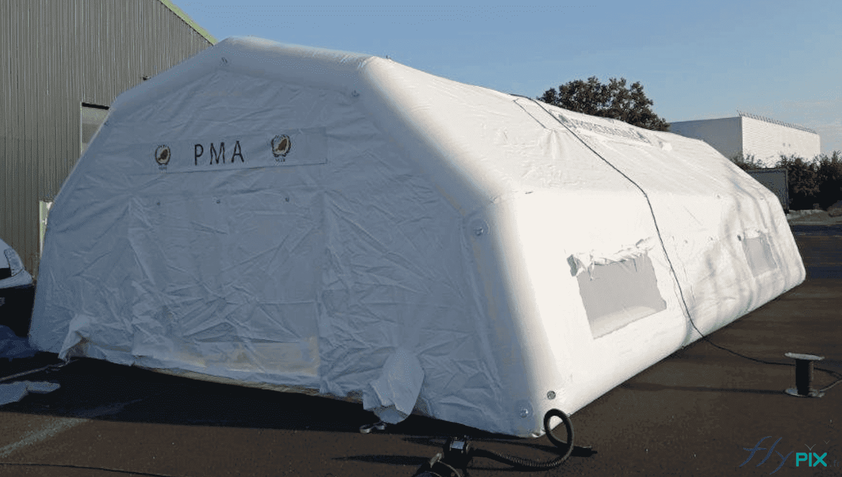 , Bertrand Export Brisbane / Prony Resources en Nouvelle-Calédonie, Melanesie: tente PMA L = 10 m x l = 6 m,  Vue arrière de la tente PMA gonflable, avec le pignon arrière doté d'une large porte pignon de sortie. A droite et à gauche : les interfaces des manchons à air. Sur le coté latéral de la structure : fenêtres et points de jour, avec mousitquaires et volets.
