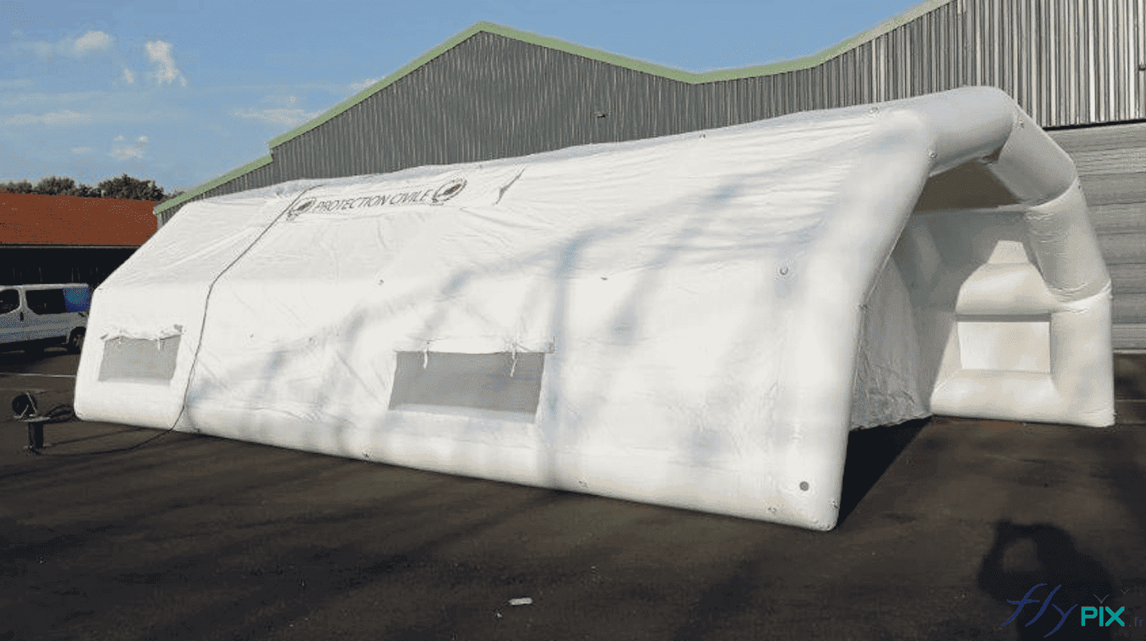 , Bertrand Export Brisbane / Prony Resources en Nouvelle-Calédonie, Melanesie: tente PMA L = 10 m x l = 6 m,  Vue latérale de l'abri gonflable PMA : fenêtres et points de jour en enveloppe PVD crystal transparent, avec volets et moustiquaires. Sur la toiture : banderoles de marquages amovibles et imprimés, fixations par bandes velcro.