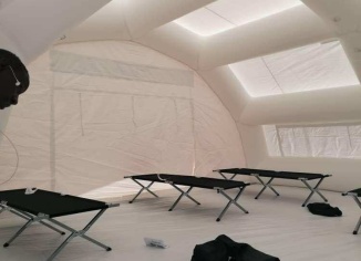 Une vue générale de l'intérieur de l'abri gonflable médical, poste de premiers secours, avec au sol des lits picots qui ont été déployés par le personnel soignant du SAMU. Au fond, une grande porte large pignon, c'est la porte de sortie. Au sol, une bâche de protection amovible de surface 60 m2. – Copyright Vivien LAÏLLE / FlyPix - Droits réservés, reproductions interdites.