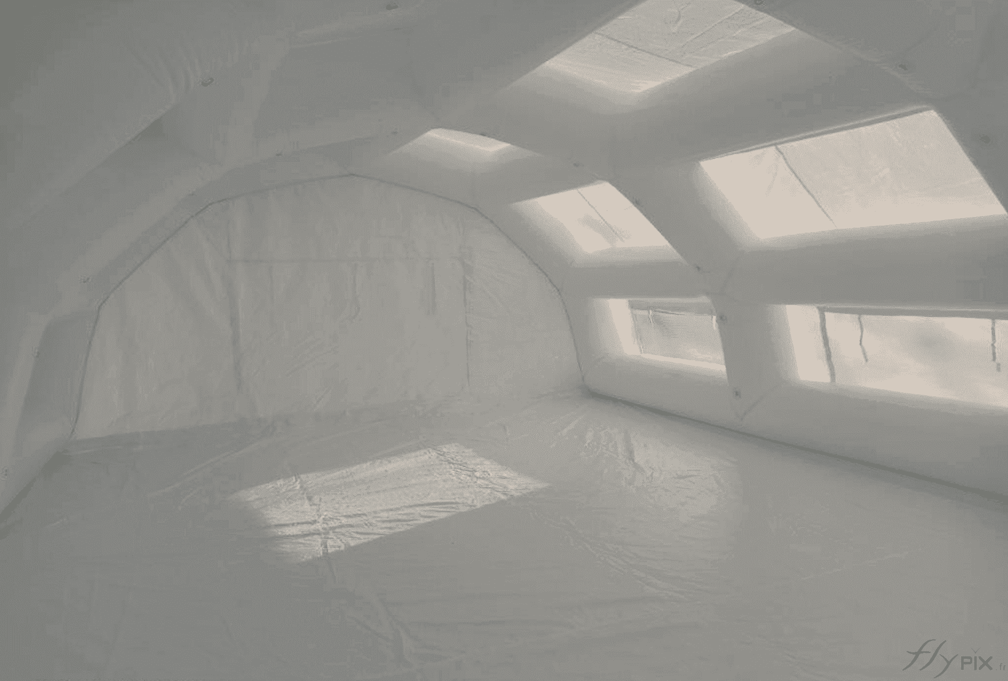 Une vue intérieure de l'abri gonflable poste de premiers secours fabriqué pour le SAMU du Centre Hospitalier SAMU d'Evreux, procurant un très grand espace, une très grande surface et un très grand volume utile de travail pour le personnel soignant et les médecins. Une bâche au sol en enveloppe PVC permet d'obtenir une zone de premiers soins propre, hygiénique et à l'abri de l'humidité. La bâche assure aussi une meilleure isolation thermique et lutte contre l'humidité en provenance du sol. La surface utile intérieure est profitable à l'accueil d'un bon nombre de patients, et celle-ci peut être aménagée avec des lits pliables médicaux, des bureaux... – Copyright Vivien LAÏLLE / FlyPix - Droits réservés, reproductions interdites.