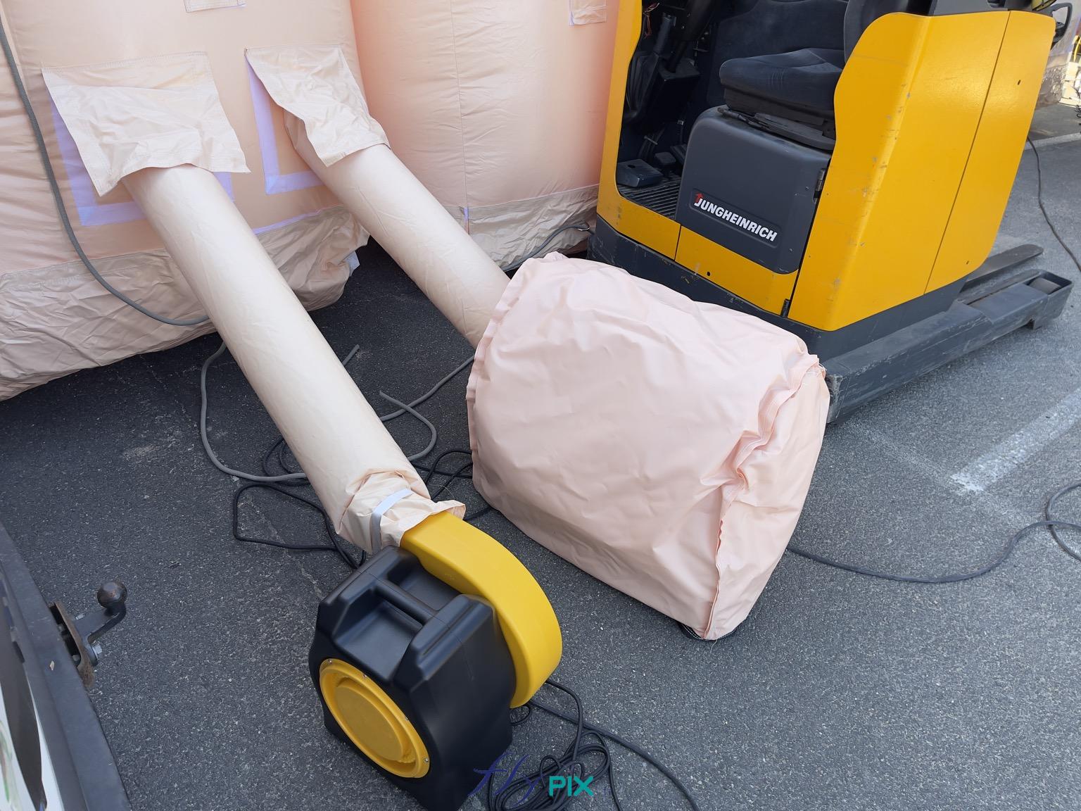 , Hangar gonflable militaire L = 25 m x l = 14 m x H = 7 m, S = 350 m2,  Nous fournissons pour chaque turbine électrique, un caisson amovible de réduction de bruits et qui protège aussi la turbine de la pluie, des intempéries et de la poussière. Le caisson est fabriqué sur mesure par nos soins, et permet une réduction de bruits de - 15 dB à - 20 dB en fonction des fréquences - Copyright : Vivien LAÏLLE/FLYPIX, droits réservés.