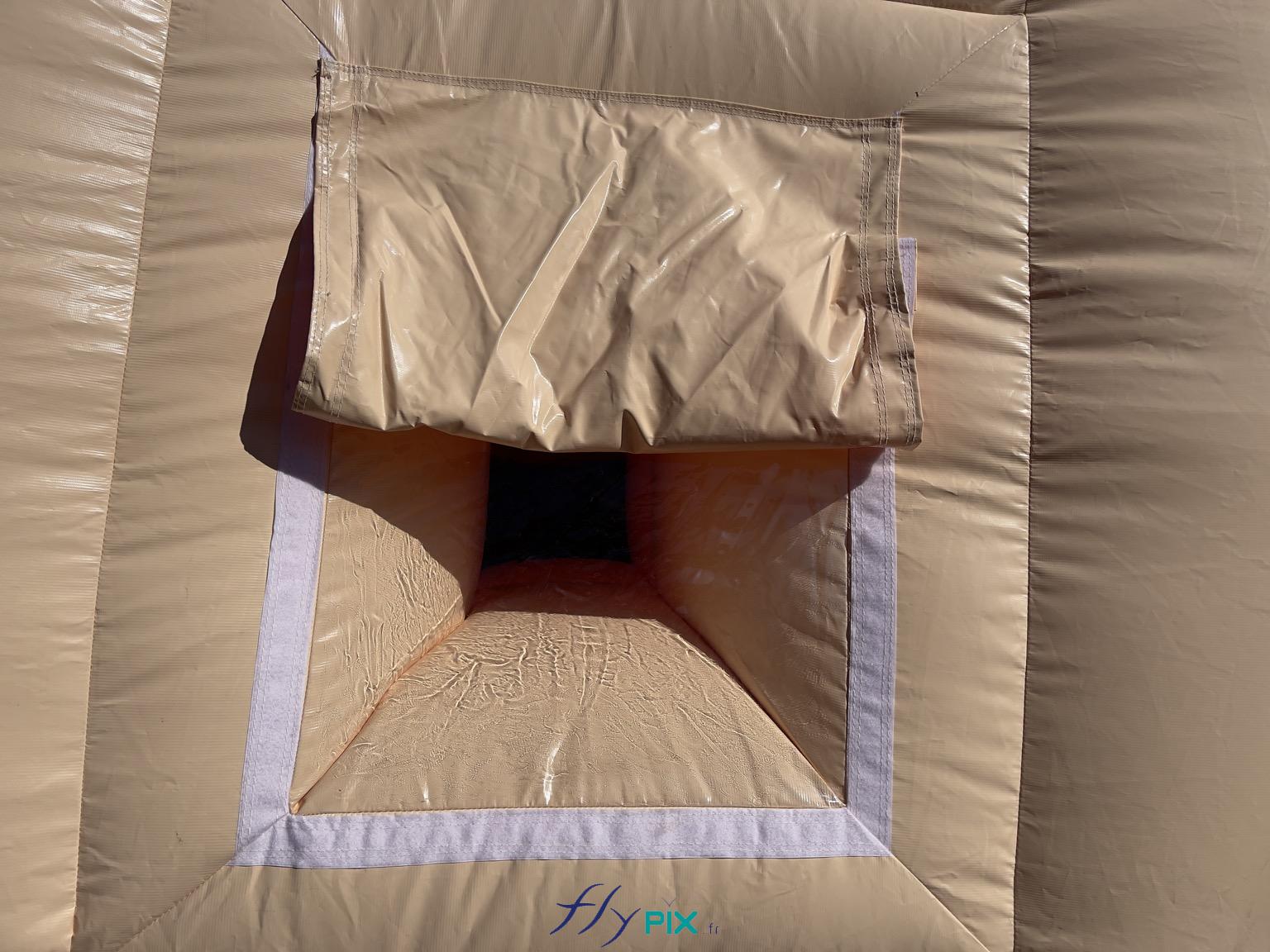 , Hangar gonflable militaire L = 25 m x l = 14 m x H = 7 m, S = 350 m2,  Une photo qui montre les détails d'une fenêtre avec PVC transparent et un volet pliable et amovible. La fenêtre permet d'avoir de la lumière naturelle à l'intérieur du hangar gonflable, durant la journée. - Copyright : Vivien LAÏLLE/FLYPIX, droits réservés.