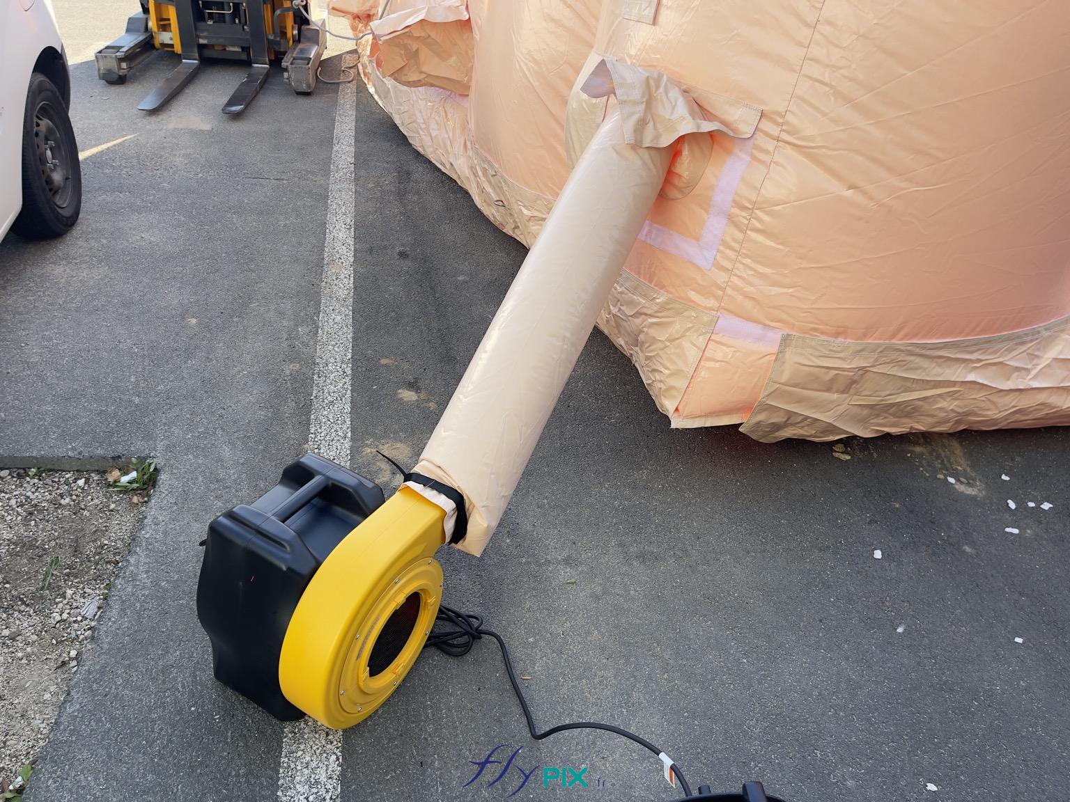 , Hangar gonflable militaire L = 25 m x l = 14 m x H = 7 m, S = 350 m2,  Une vue détaillée de la turbine et du manchon à air qui envoie de l'air dans la structure gonflable, en permanence. Cette turbine électrique fait une puissance de 2500 W environ. Il faut idéalement plusieurs turbines pour gonfler la structure gonflable. - Copyright : Vivien LAÏLLE/FLYPIX, droits réservés.