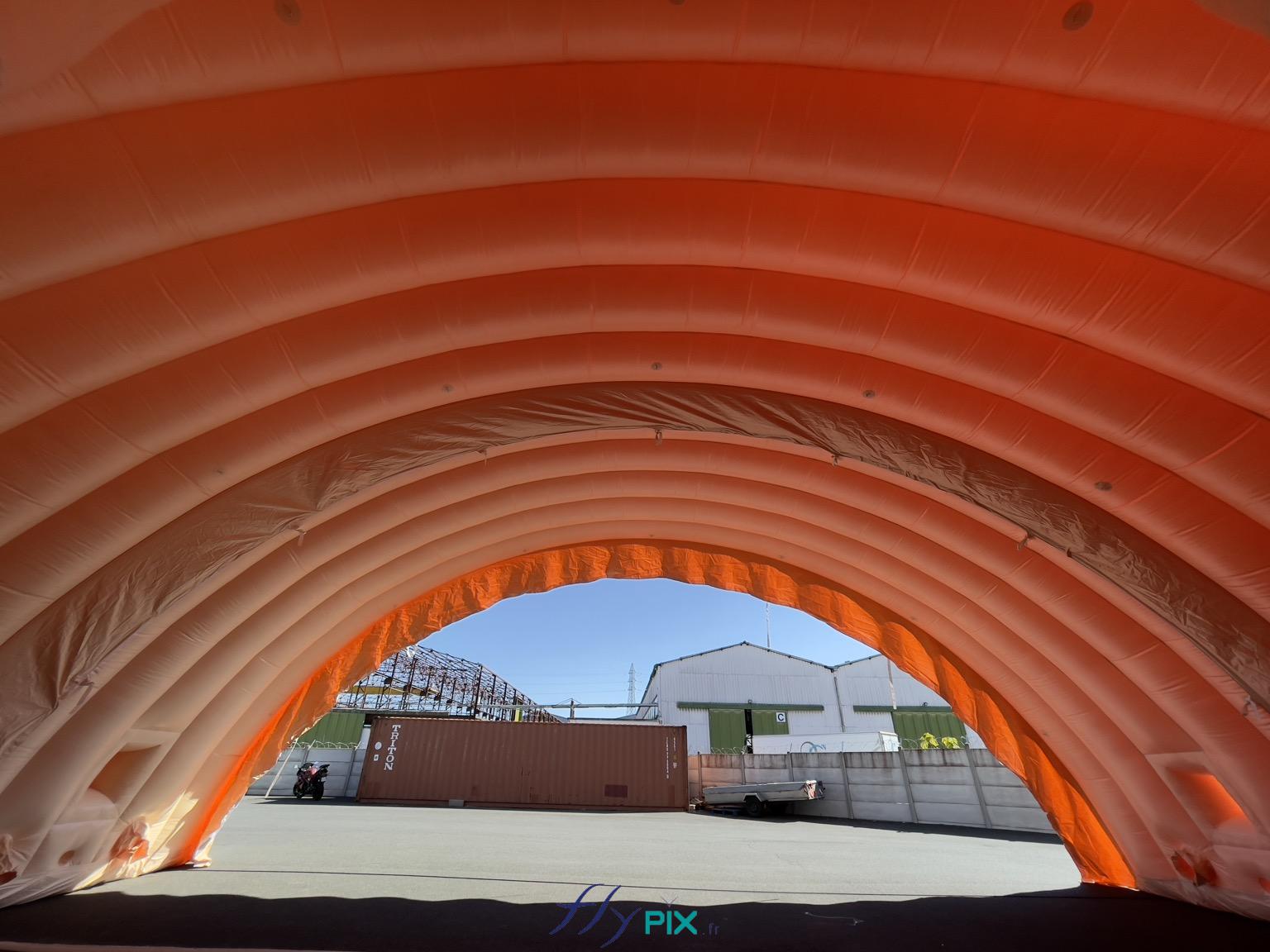 , Hangar gonflable militaire L = 25 m x l = 14 m x H = 7 m, S = 350 m2,  Le hangar gonflable est composé en tout de 5 modules, qui une fois connectés, assembles et jointés procurent un très grand volume et une très grande surface de travail. La hauteur utile est haute et la largeur utile conséquente, ce qui permet une grande polyvalence en ce qui concerne l'utilisation de ce hangar gonflable militaire. Aussi les modules gonflables peuvent être agencés avec ou sans les pignons, sur 1 ou plusieurs sites militaires, en fonction des besoins opérationnels sur le terrain. - Copyright : Vivien LAÏLLE/FLYPIX, droits réservés.