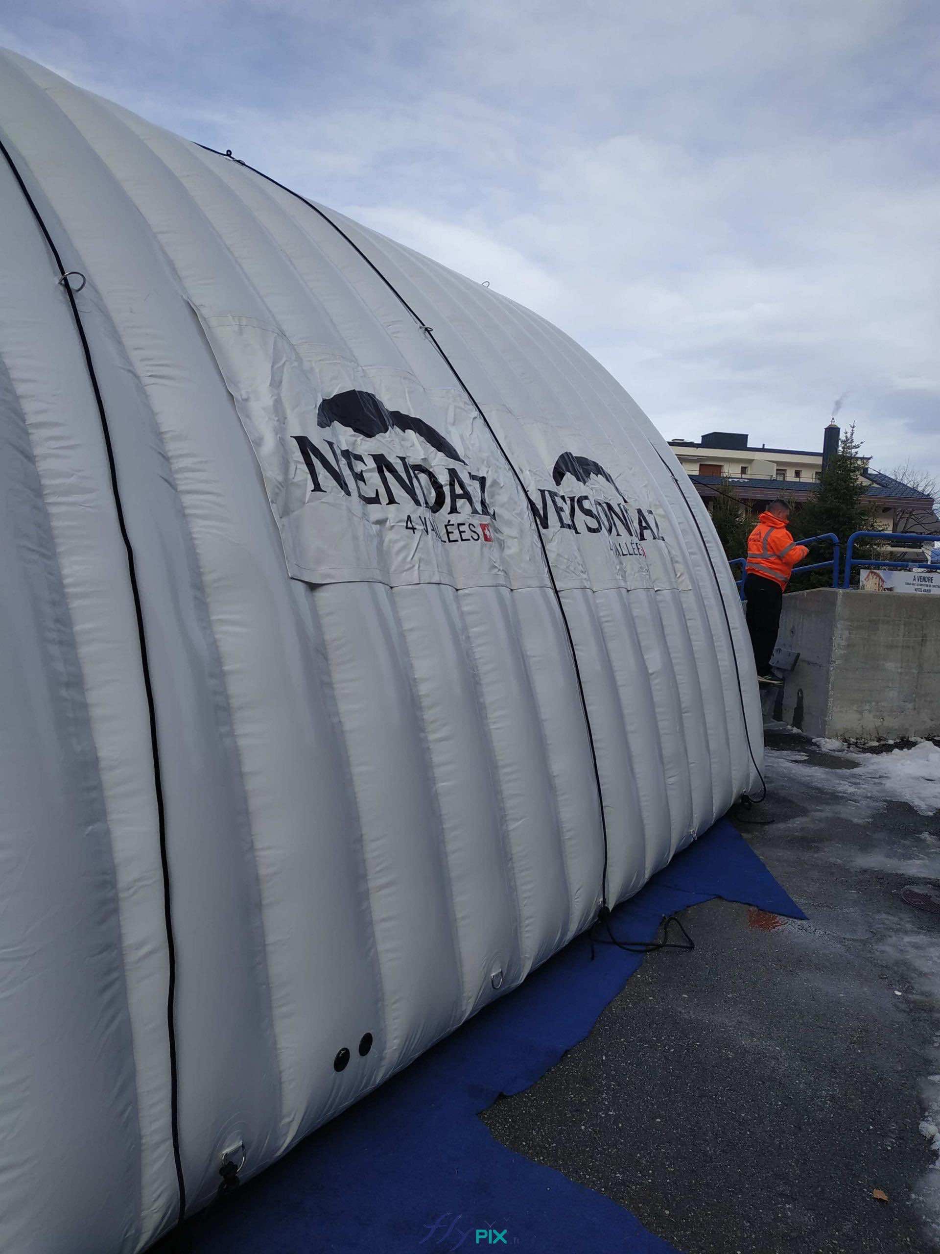 Sur les deux murs latéraux de la structure gonflable, sont fixées deux bâches de banderoles imprimées amovibles, avec le logo NENDAZ, qui sont fixées par des bandes velcro. Sur les deux murs latéraux de la structure gonflable, sont fixées deux bâches de banderoles imprimées amovibles, avec le logo NENDAZ, qui sont fixées par des bandes velcro.