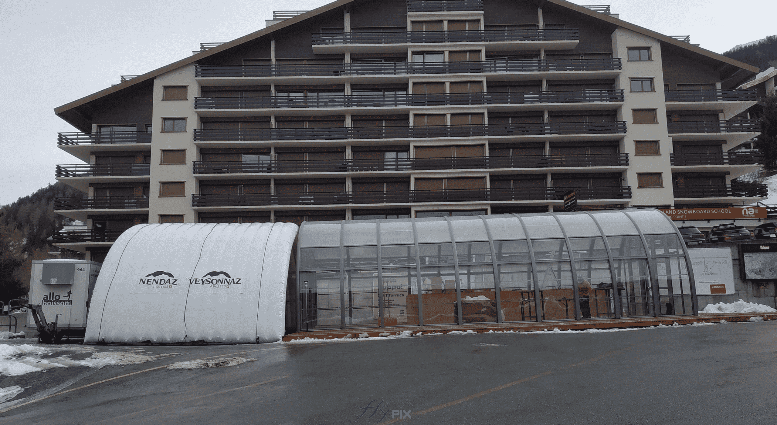 Cette photographie montre une vue générale de l'ensemble des deux structures. A gauche la tente gonflable tunnel, et à droite, la structure à armatures métalliques et en panneaux de verre. Cette photographie montre une vue générale de l'ensemble des deux structures. A gauche la tente gonflable tunnel, et à droite, la structure à armatures métalliques et en panneaux de verre.