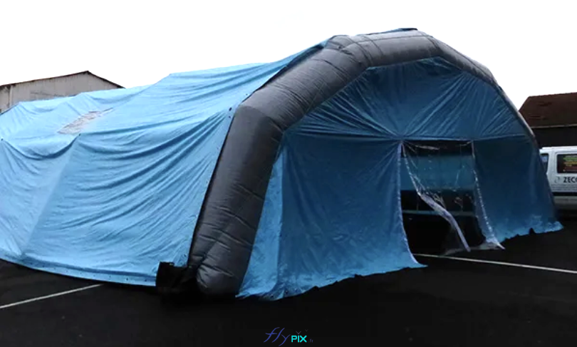 Vue de la façade avant, le pignon avant avec la porte, d'un abri gonflable de chantier BTP ou piscine en forme de tunnel, entièrement en enveloppe PVC 0.45 mm simple peau. Cette tente gonflable est gonflée à l'air avec une turbine électrique en permanence. Vue de la façade avant, le pignon avant avec la porte, d'un abri gonflable de chantier BTP ou piscine en forme de tunnel, entièrement en enveloppe PVC 0.45 mm simple peau. Cette tente gonflable est gonflée à l'air avec une turbine électrique en permanence.