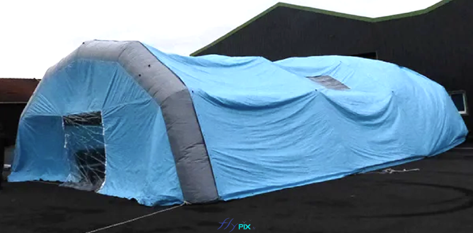 Une vue générale d'une tente gonflable en forme de tunnel, en enveloppe PVC 0.45 mm simple peau. Cette structure gonflable est gonflée à l'air avec une turbine électrique en permanence. Cet abri gonflable de chantier a été fabriqué sur mesure par nos soins, dans nos ateliers en France à Orléans. Une vue générale d'une tente gonflable en forme de tunnel, en enveloppe PVC 0.45 mm simple peau. Cette structure gonflable est gonflée à l'air avec une turbine électrique en permanence. Cet abri gonflable de chantier a été fabriqué sur mesure par nos soins, dans nos ateliers en France à Orléans.