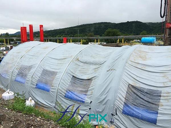 SOL ENVIRONNEMENT : tente gonflable de chantier en forme de tunnel demi-lune, pour la dépollution de site, dans le cadre de chantier d'excavation de sols pollués.
