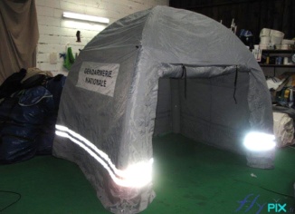 Gendarmerie nationale : barnum gonflable. Forme : Igloo Matériaux : Boudins d'ossature enveloppe PVC 0.6 mm, simple peau, jointures soudées Murs et toitures en enveloppe PVC 0.45 mm, simple peau, jointures soudées. Bandes réfléchissantes pour la lumière.