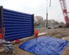 Grand Paris Express, chantier urbain de Meudon : cette photo est intéressante parce qu'elle montre plusieurs choses essentielles qui concerne les structures gonflable de murs de réduction de bruits. Premièrement, au premier plan, au sol, un écran gon flable est déployé sur toute sa surface, dans l'attente de son gonflage à l'air avec une pompe électrique. C'est une structure air captif. Deuxièmement, en arrière plan, nous observons un mur gonflé, positionné verticalement sur une structure en béton et avec des poutres métalliques. Cette configuration procure une très grande résistance structurelle aux vents, tout en minimisant au maximum l'emprise au sol, en limitant la présence et l'utilisation de sacs de lestages à remplir de sable. Tout en conservant une grande mobilité et un très bon réemploi.