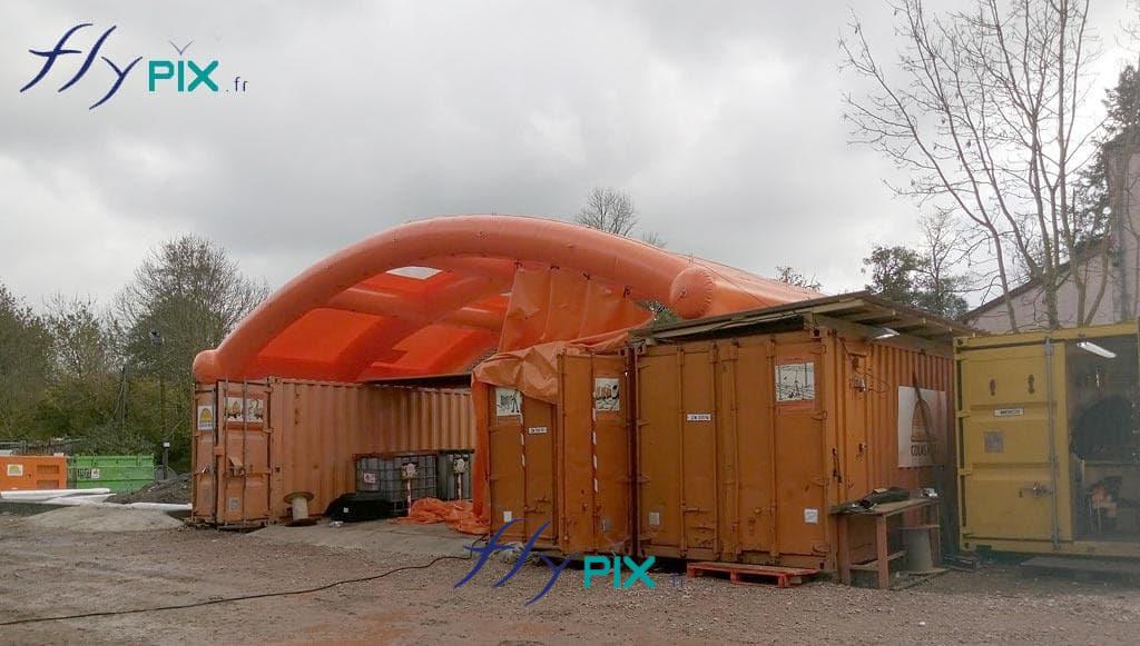 Toit gonflable en voûte (ou demi-lune) inter-conteneurs. En exploitant astucieusement le mobilier logistique déjà présent sur site — les conteneurs maritimes de stockage ISO de 20 ou 40 pieds —, ce système utilise ces blocs d'acier comme des fondations structurelles stables et rigides. L'installation d’une voûte pneumatique autonome entre deux conteneurs crée immédiatement une cellule de travail abritée, sèche et optimisée, sans emprise au sol supplémentaire. Toit gonflable en voûte (ou demi-lune) inter-conteneurs. En exploitant astucieusement le mobilier logistique déjà présent sur site — les conteneurs maritimes de stockage ISO de 20 ou 40 pieds —, ce système utilise ces blocs d'acier comme des fondations structurelles stables et rigides. L'installation d’une voûte pneumatique autonome entre deux conteneurs crée immédiatement une cellule de travail abritée, sèche et optimisée, sans emprise au sol supplémentaire.